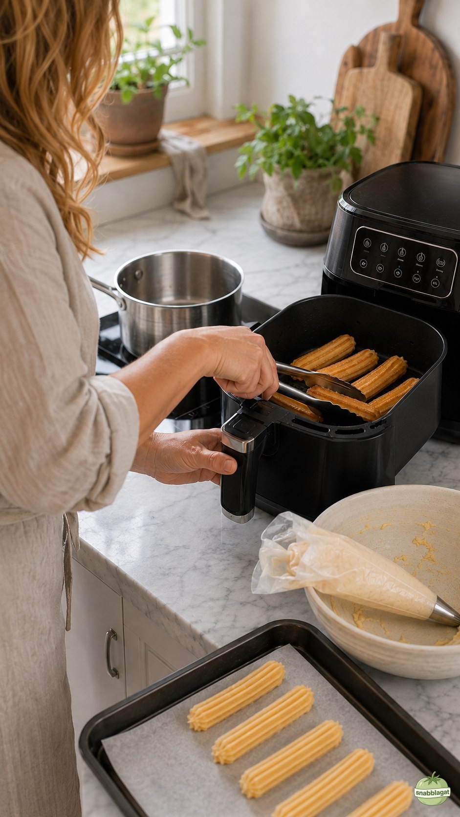 Churros läggs i luftfritösens korg med tång för tillagning i köket