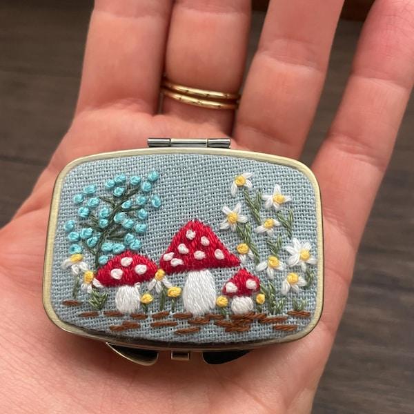 Broderad liten tygdekoration med motiv