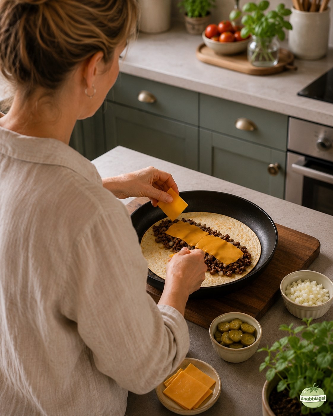 Cheddarost läggs över nötfärs i tortilla för cheeseburger crunch wrap