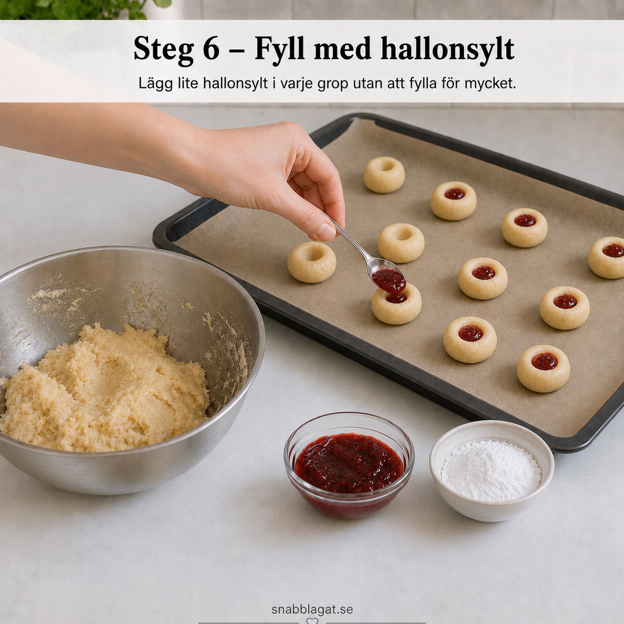 Sked fyller hallonsylt i gropen på varje kaka innan gräddning av hallongrottor
