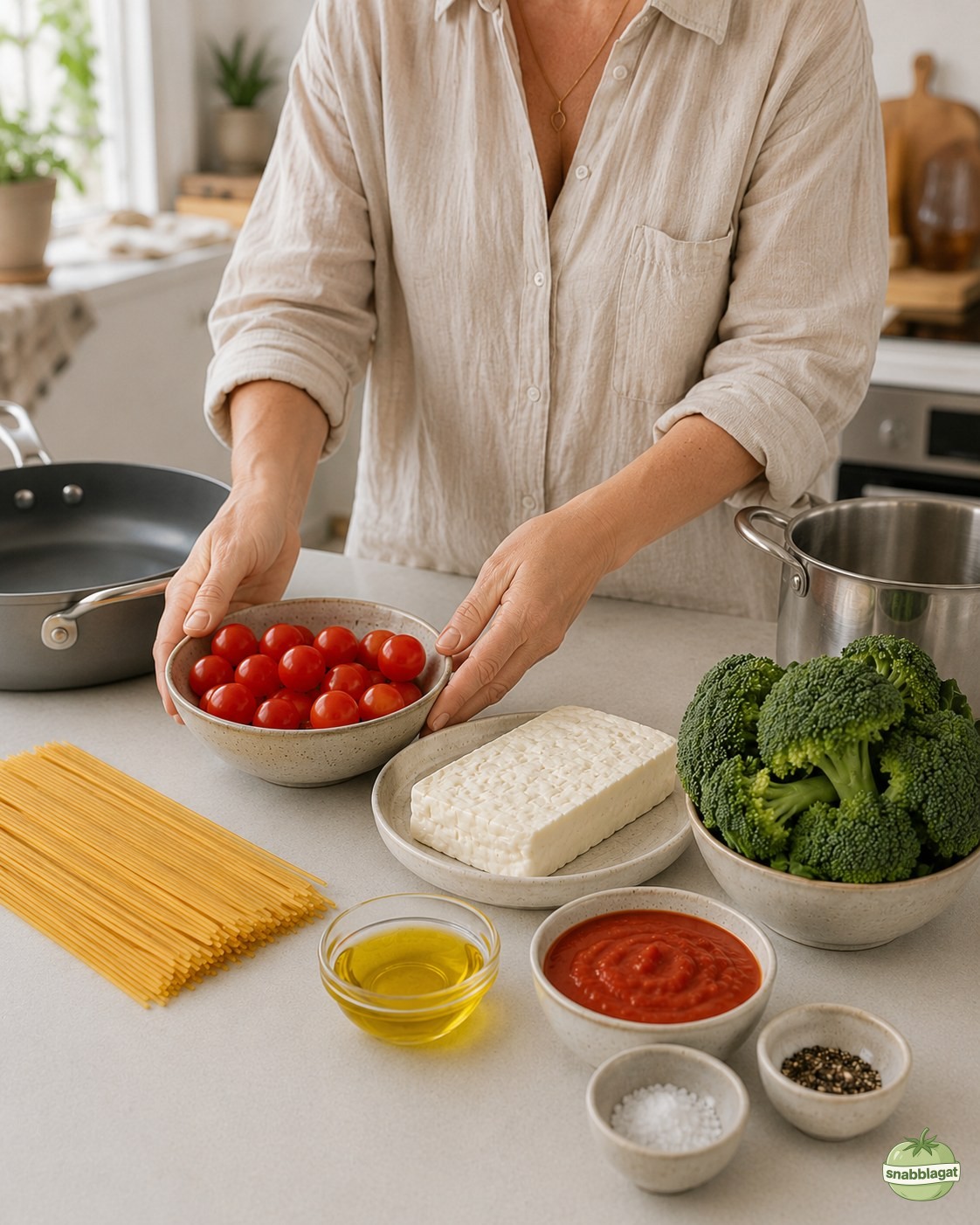 Kvinna lägger fram ingredienser till halloumipasta med broccoli i hemmakök