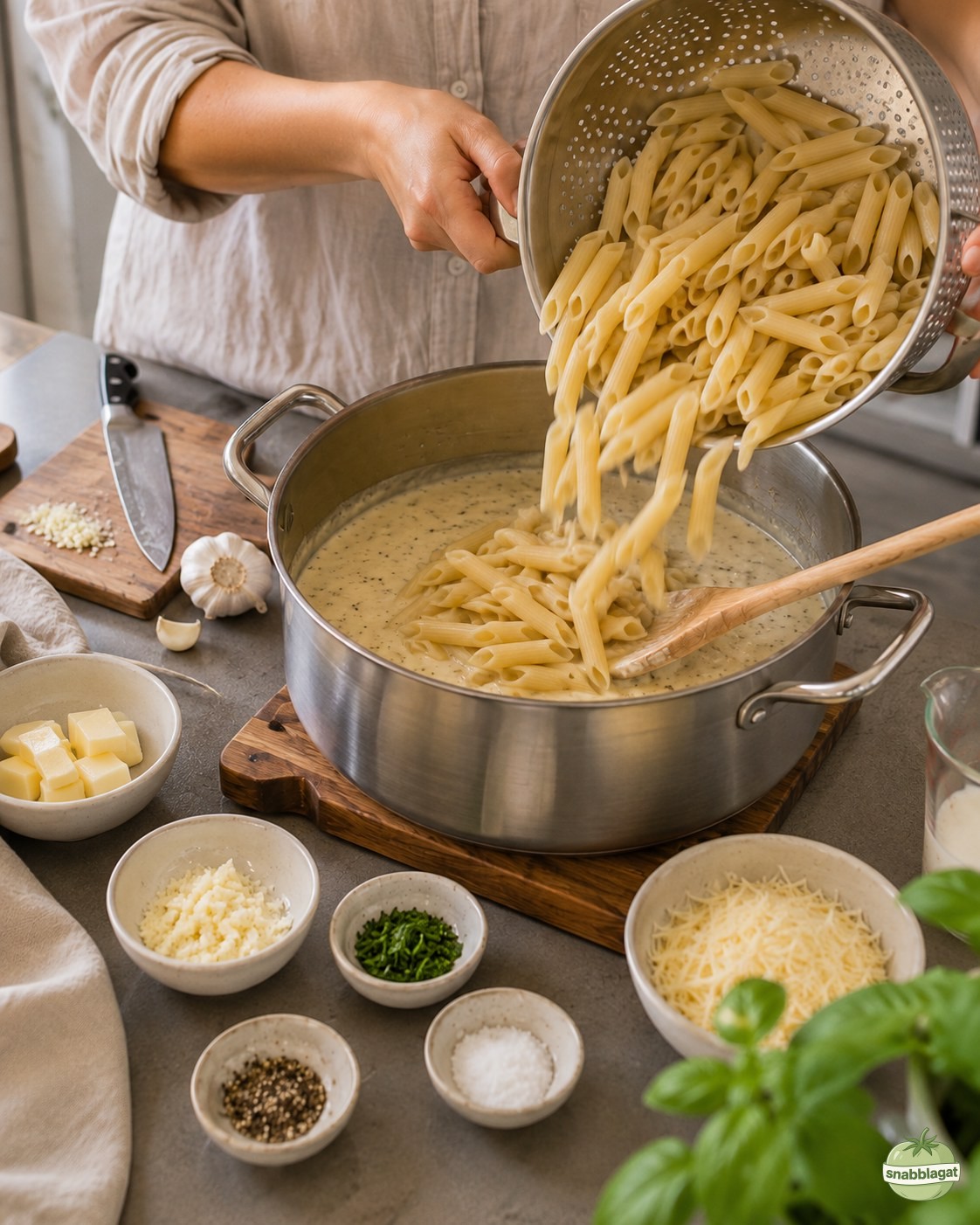 Avrunnen pasta hälls ner i krämig vitlökssås i kastrull