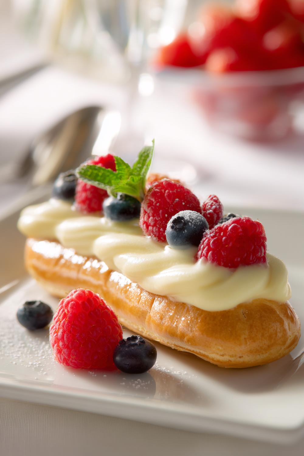 19. Vaniljkräm dessert som éclair med glasyr och bärdekoration